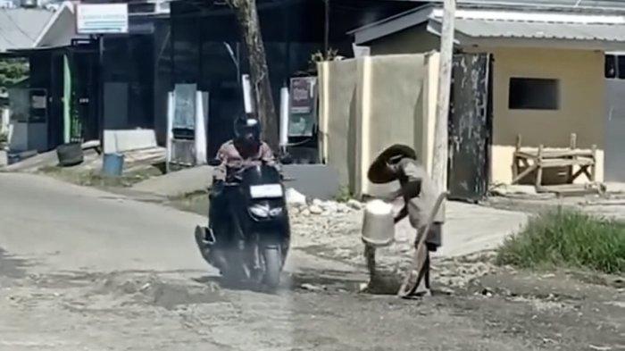 Tangkapan layar seorang warga melakukan penumbunan jalan sendirian di Jl Pengayoman Kekurahan Rimuku Mamuju, Sulbar. Senin (15/7/2024).
