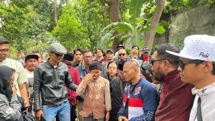 TANGIS ANAK KANG GOBANG - Anak Kang Gobang (tenga) tak kuasa menahan tangisnya saat didekat rekan ayahnya, Kang Murad (tiga dari kanan) di Pemakaman Kang Gobang di TPU Cibabat Kota Cimahi, Jumat (7/2/2025). Kang Murad sampaikan pesan menyentuh untuk keluarga dan anak Kang Gobang.
