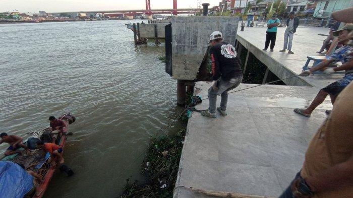 Para pekerja dibantu tim selam tradisional mengevakuasi bahan bangunan yang tenggelam bersama Jukung Motor Sungai Sama Cinta 08 depan Dermaga 16 Ilir, Jumat (23/8/2024).