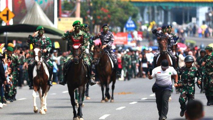 Pasukan Defile Berkuda melintas di depan podium kehormatan dan memberi hormat pada Defile HUT ke-79 TNI di depan Makodam II Sriwijaya, Jalan Jenderal Sudirman, Sabtu (5/10/2024).