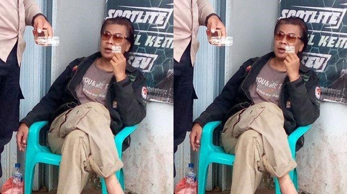 PELAKU BUNUH ADIK. Prengki duduk santai sambil merokok di kursi di pinggir jalan, Kampung Ciparay usai membunuh kakak kandungnya sendiri di halaman rumah kontrakannya ,Sabtu (22/02/2025).