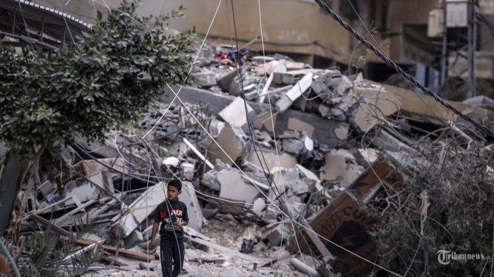 Seorang anak laki-laki berjalan di tengah reruntuhan bangunan yang hancur akibat serangan udara Israel di Kota Gaza pada 7 Oktober 2023. Pejuang Palestina telah memulai