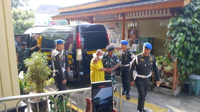 SIDANG PERDANA -- Dua oknum TNI yang terlibat dalam kasus penembakan tiga orang anggota polisi di Lampung Kopka Basarsyah dan Peltu Lubis dikawal ketat anggota TNI saat masuk ke gedung Pengadilan militer I-04 Palembang, Rabu (11/6/2025). Sidang perdana dengan agenda pembacaan dakwaan.