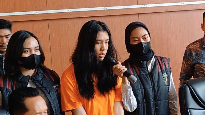 Tampang Ghisca Debora Aritonang, wanita yang viral diburu diduga penipuan tiket konser Coldplay akhirnya ditangkap. Tampang menunduk kenakan baju oranye