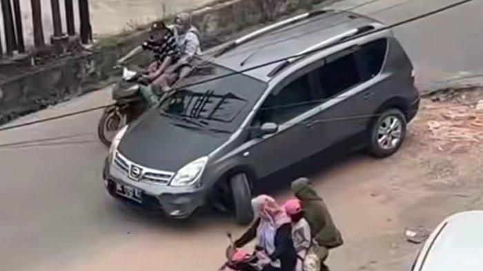 Tangkapan layar mobil hitam patah roda depan kiri karena masuk lobang besar di simpang 3 jalan Suara Sako persisnya di simpang 3 Polsek Sako.