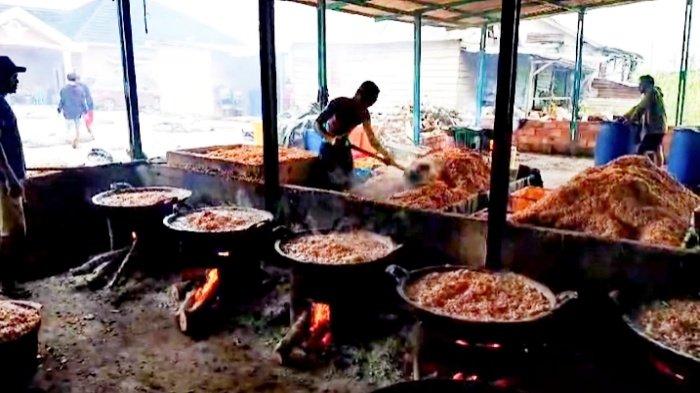 Beberapa pekerja sibuk mengontrol besarnya api di rumah produksi udang kering di Tanjung Lago, Kabupaten Banyuasin, Sumsel, Minggu (6/10/2024)