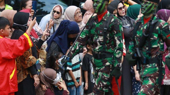 Warga kota Palembang antusias menyaksikan Defile Pasukan dan Alutsista TNI di depan Makodam Sriwijaya, Jalan Jenderal Sudirman, dalam rangka memperingati HUT ke-79 TNI, Sabtu (5/10/2024).