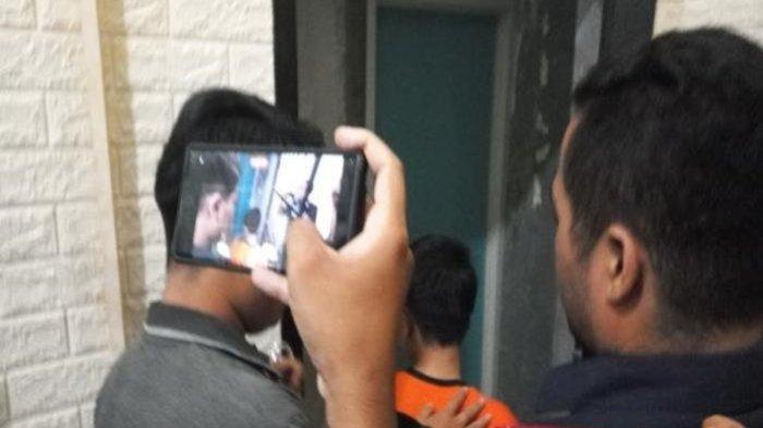 Rahmat (baju oranye), pelaku pembunuhan terhadap ibu kandungnya, saat diamankan polisi dan digiring ke tahanan Satreskrim Polres Sukabumi, Selasa (14/5/2024) sore. Ia membunuh ibunya lalu tidur di dekat jasad sang ibu