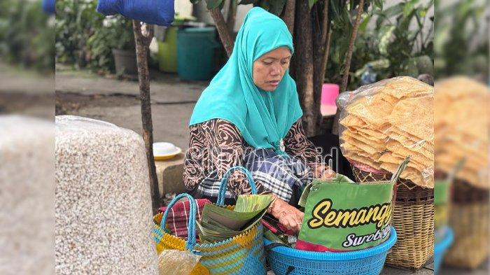 SEMANGGI SUROBOYO - Yati tengah menyiapkan sebungkus semanggi, kuliner khas Suroboyo. Panganan ini merupakan olahan daun semanggi yang direbus kemudian disandingkan dengan ubi jalar, kecambah dan bumbu kacang di atas pincuk daun.