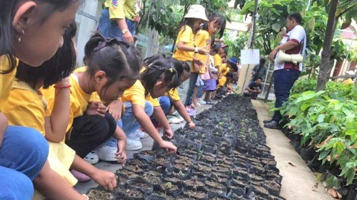 Anak-anak belajar menanam bibit kakao di Kampung Coklat Blitar, Rabu (13/12/2023).