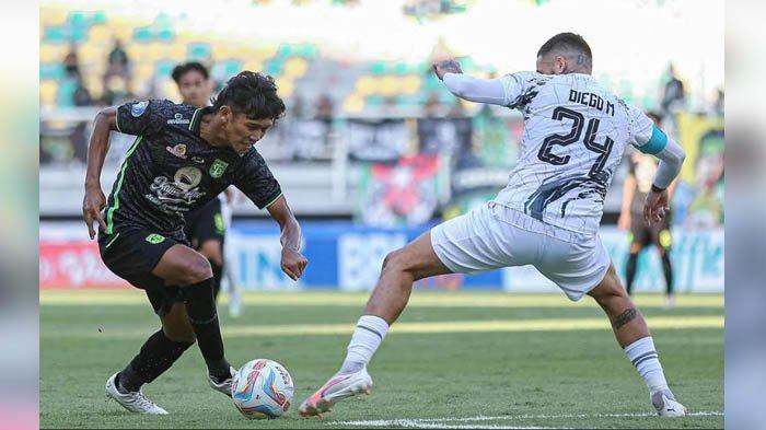 Bek kanan Persebaya, Arief Catur dihadang pemain Borneo FC di Stadion GBT pada Minggu (3/9/2023) sore.