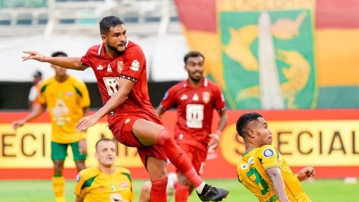 Ardi Idrus (Kanan) berupaya menghalau tendangan Junior Brandao (kiri) di laga Persebaya vs Malut United