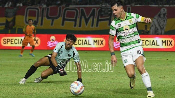 Kapten Persebaya, Bruno Moreira melewati hadangan kiper Persibo di Stadion GBT, Sabtu (29/6/2024) malam dalam Anniversary Game ke-97.