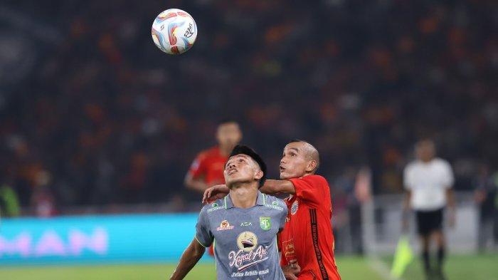 Kasim Botan saat berebut bola melawan Riko Simanjuntak di laga Persija vs Persebaya Surabaya di Stadion Gelora Bung Karno, Jakarta, Minggu (30/7)
