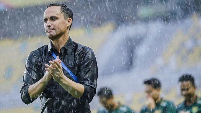 Pelatih Persebaya Surabaya, Paul Munster merayakan kemenangan melawan Bhayangkara FC di bawah guyuran hujan di Stadion Gelora Bung Tomo, Surabaya.