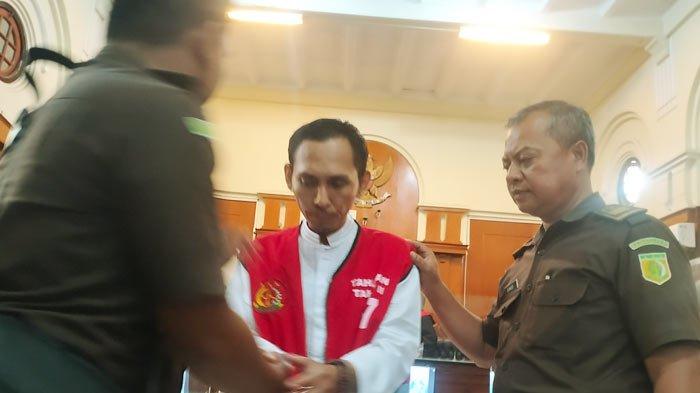 Terdakwa Rochmad Bagas Apriyatna (41) alias Roy pasrah tangannya dipasang borgol usai mendengar sidang vonis di Pengadilan Negeri (PN) Surabaya, Kamis (4/1/2024).