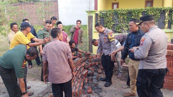 Warga dan Forkopimka tengah membongkar tembok yang menutup akses jalan di Jalan Gang Rajawali, Kelurahan/Kecamatan Kademangan, Kota Probolinggo. Tembok dibangun imbas perselisihan antar warga.
