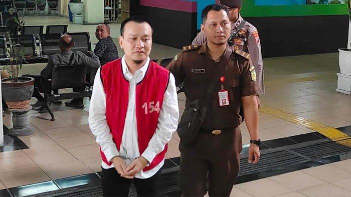 KASUS PAKSA SISWA MENGGONGGONG - Terdakwa kasus perundungan anak, Ivan Sugianto didampingi petugas menuju ruang sidang di Pengadilan Negeri Surabaya, Rabu (12/2/2025). Sidang hari ini beragenda eksepsi, di mana terdakwa menyampaikan telah melakukan perdamaian dengan korban, sebelum kasus dilaporkan.