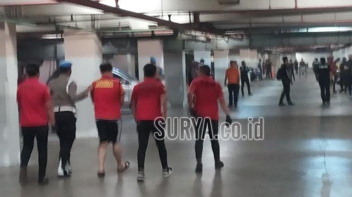 Suasana basement TKP di Lenmarc Mall. Terdapat garis batas Polisi terpasang. Tersangka saat dibawa anggota kepolisian untuk menjalani rekonstruksi