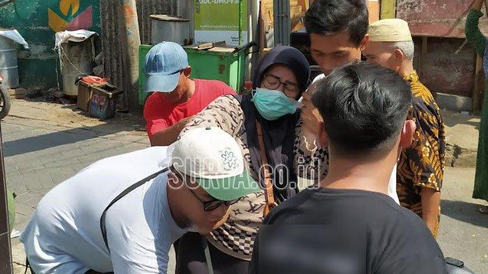 Kerabat korban pingsan di tengah jalan saat mengantar jenazah ke pemakaman TPU Jarak Kota Surabaya, Senin (20/11/2023).