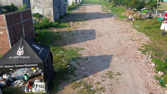 BERMASALAH - Kondisi tampak atas lokasi proyek tanah kavling milik PT Makmur Tentram Berprestasi (MTB) Property di Dusun Alas Tipis, Desa Pabean, Kecamatan Sedati, Kabupaten Sidoarjo, Jawa Timur pad Jumat (18/7/2025). Pembeli tanah kavling ini mengeluh, karena unit tanah kavling tak kunjung terealisasi meski sudah membayar ratusan juta rupah kepada pengembang.