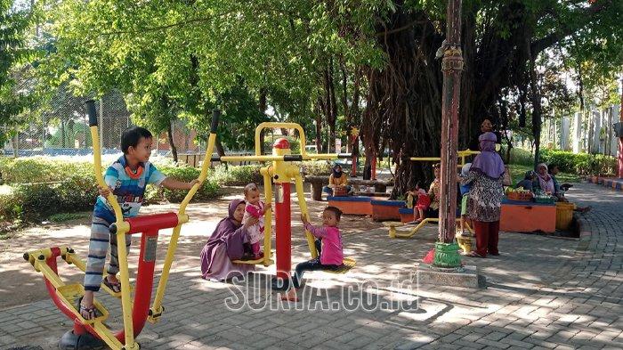 Pengunjung bersama keluarganya menikmati libur Tahun Baru 2025 di Taman Kebon Rojo Jombang, Kamis (2/1/2025).