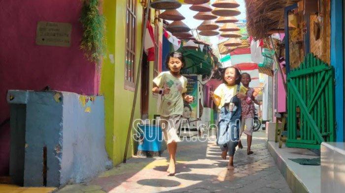 Anak-anak yang tinggal di Kampung Warna Warni Jodipan Malang bermain di dalam kampung karena wisatanya ditutup, Sabtu (22/8).