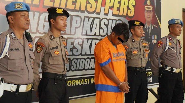 Tersangka pembunuhan terhadap sepupunya, Rully Irwansyah (23) saat digelandang petugas di Mapolresta Sidoarjo, Senin (7/8/2023).