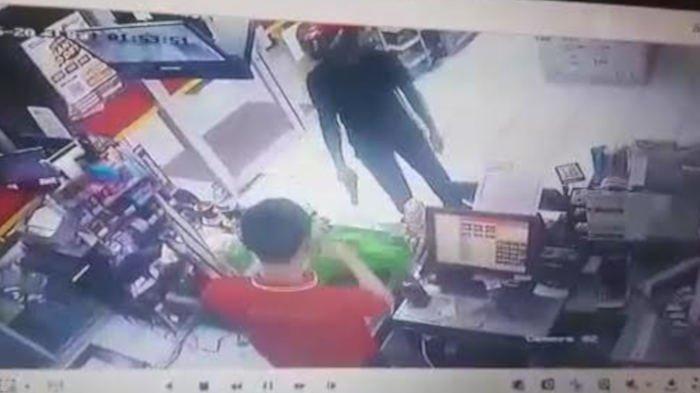 Tangkapan layar video CCTV yang mereka aksi perampok menodongkan pistol ke karyawan minimarket di Duduksampeyan, Gresik.