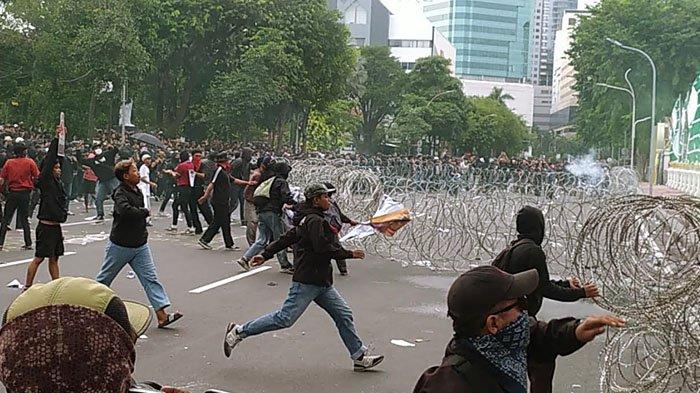 DEMO TOLAK UU TNI RICUH - Kericuhan yang berujung pada pelemparan beberapa bom molotov, bebatuan dan petasan mewarnai demo tolak UU TNI di depan Gedung Negara Grahadi Surabaya, Senin (24/3/2025).