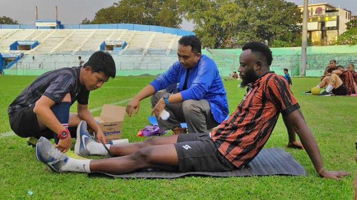 Winger Arema FC, Charles Lokolingoy, saat mendapatkan perawatan dari tim medis Arema FC saat menjalani latihan di Stadion Gajayana Malang.