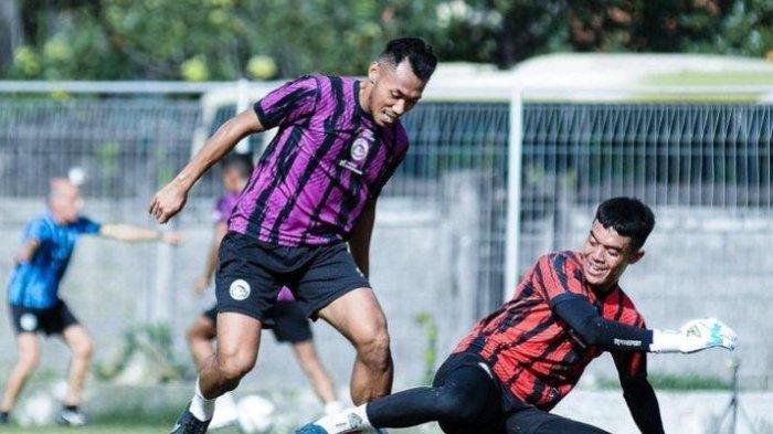 Bek Arema FC Arsyaq Gufron saat berduel dengan kiper Teguh Amiruddin dalam sesi latihan.