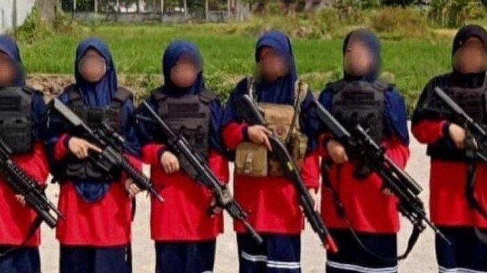 Foto sejumlah santriwati mengenakan jilbab biru tua dengan baju kaos warna merah menenteng senjata laras panjang yang beredar di sejumlah media social menjadi viral di Kabupaten Magetan, Jawa Timur. Dalam foto tersebut santriwati juga terlihat mengenakan rompi menyerupai rompi antipeluru. (KOMPAS.COM)