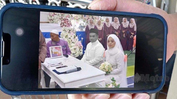Kerabat menunjukkan foto pernikahan Aini dan Norsyam 1