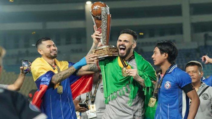 Kiper Arema FC, Lucas Frigeri mengangkat Piala Presiden 2024 saat merayakan gelar juara Piala Presiden 2024 di Stadion Manahan Solo pada Minggu (4/8/2024).