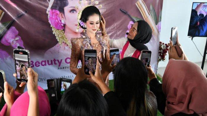 Peserta mengabadikan momen menggunakan smartphone saat pelatihan merias pengantin oleh MUA Kota Malang Yulia Maria di Gedung MCC (Malang Creative Center), Kota Malang, Jawa Timur, Sabtu (12/8/2023).