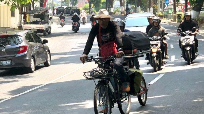 Mengenang Tragedi Stadion Kanjuruhan, Miftahudin Ramli saat melintas di Jalan Kota Batu untuk memulai ekspedisi lintas stadion, Kamis (3/8/2023).