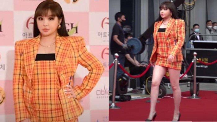 Park Bom mengenakan setelan jas motif kotak-kotak berwarna oranye