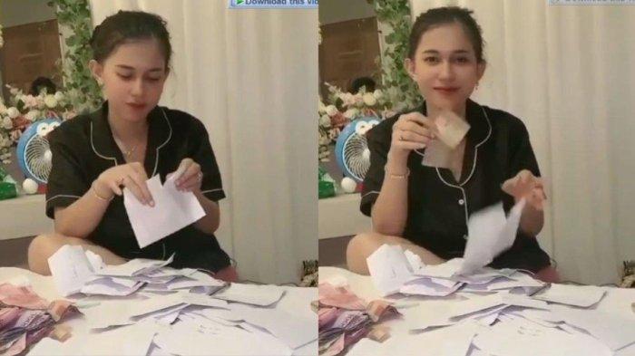 Pengantin wanita yang sudah berganti pakaian menggunakan piyama itu nampak duduk di atas ranjang yang dipenuhi dengan banyak amplop.