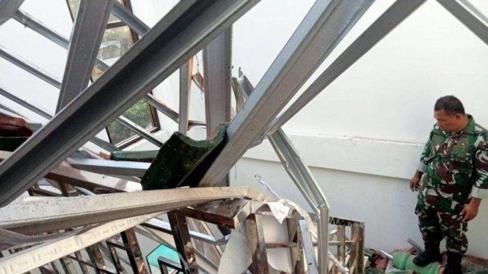 Petugas Babinsa TNI memeriksa atap bangunan kantor KUA roboh akibat gempa Pangandaran