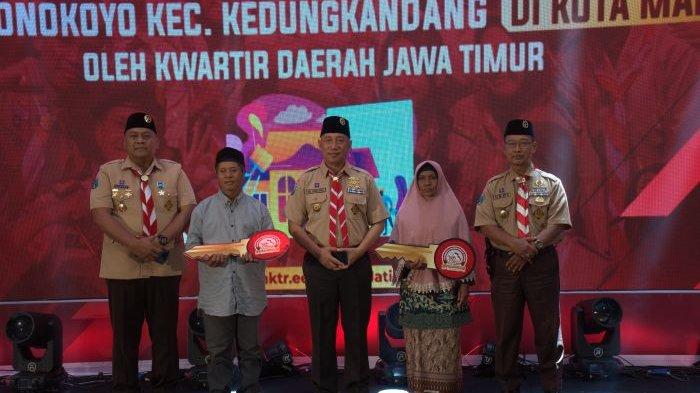 Ketua Kwarda Jawa Timur, H. M. Arum Sabil, S.P., S.H., memberikan kunci (simbolis) kepada penerima bantuan bedah rumah dari Kepramukaan Jawa Timur (30/11).