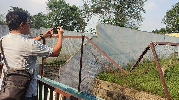 Seorang pengunjung mengabadikan kondisi salah satu kandang hewan di Medan Zoo