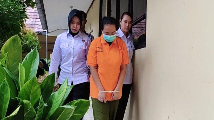 Tersangka Kasus kopi sianida yang merenggut nyawa siswa SMP di Pacitan saat digiring polisi di Mapolres Pacitan. pelaku tak lain adalah Tetangga dekat korban.