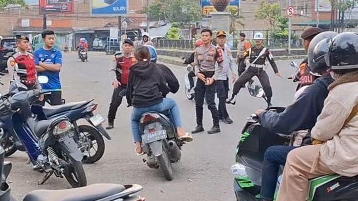 KABUR - Pengendara menerobos petugas yang melakukan razia di Jalan Raya Katapang-Soreang, Kecamatan Katapang, Kabupaten Bandung, Jumat (30/5/2025).