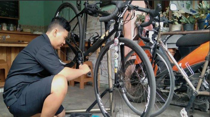 Pemilik bengkel sepeda Kopi Bike, Achmad Mukhlis (33) saat sedang memperbaiki sepeda milik kustomernya, Minggu (17/11/2024).