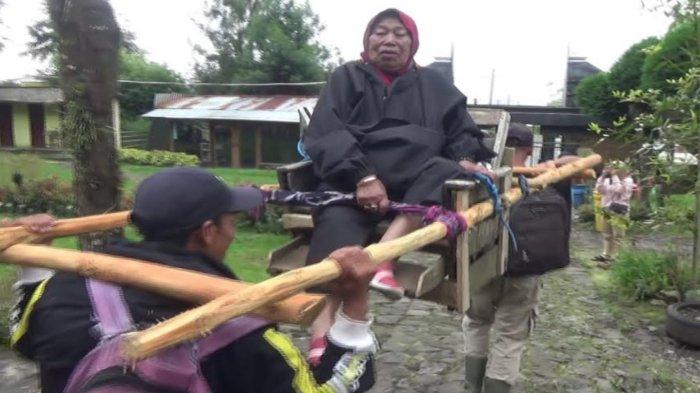 Mbok Yem saat ditandu oleh dua orang menuruni Puncak Gunung Lawu demi pulang kampung Hari Raya Idul Fitri