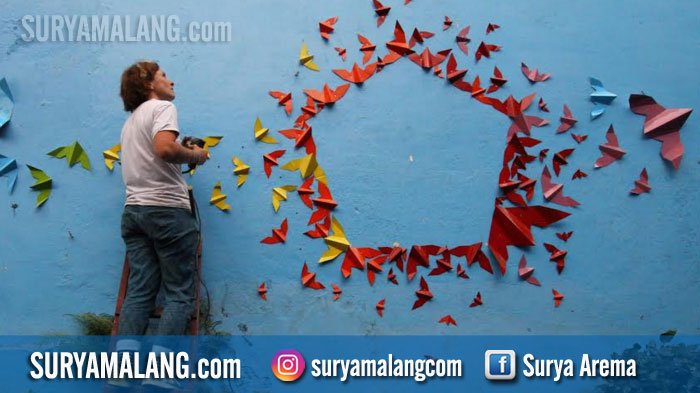 INSTALASI ORIGAMI - Seniman origami Perancis, Mademoiselle Maurice membuat seni instalasi origami di Kampung Biru Arema, Kota Malang, Rabu (8/8/2018). Seniman yang telah membuat karya origami di sejumlah negara dan lokasi ini singgah di Kota Malang memberikan workshop origami dan membuat karya permanen di Kampung Biru Arema.