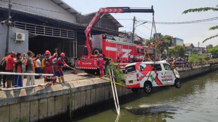 Petugas Damkar mengevakuasi mobil Riwa-Riwi menggunakan crane milik Damkar, Kamis (19/9/2024)