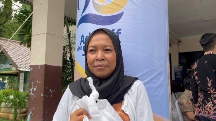 Siti mendapatkan sembako dalam kegiatan Pasar Murah Bank Mandiri.