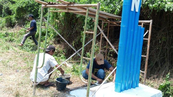 Mahasiswa dan Pemdes setempat saat mengecat Gapura yang dibangun, Kamis (5/10/2023)